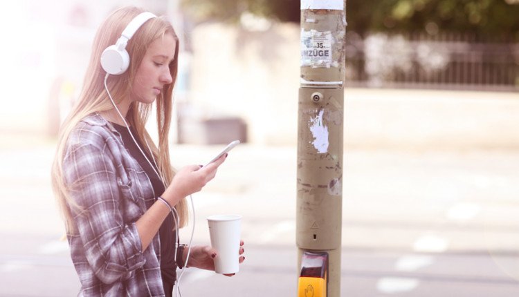 Teenager nutzt Smartphone und Kopfhörer