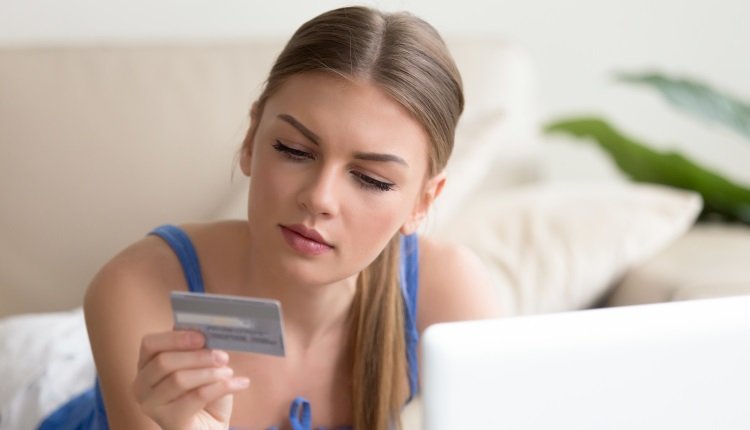 Frau mit Kreditkarte am PC