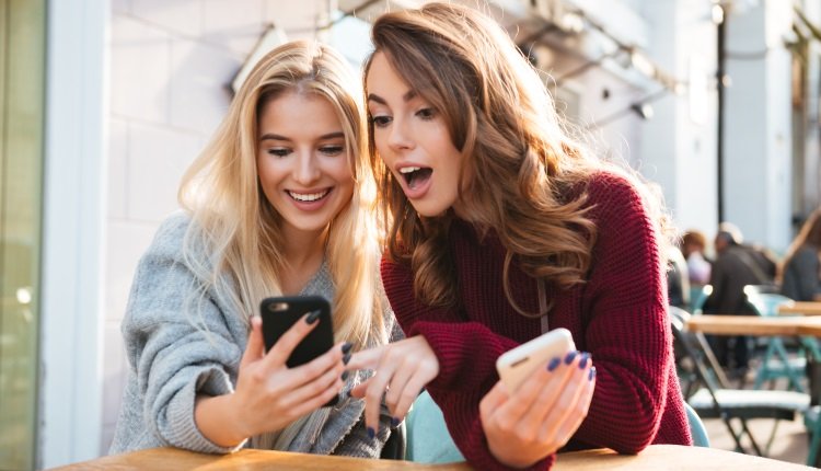 Zwei Frauen schauen auf ihr Handy